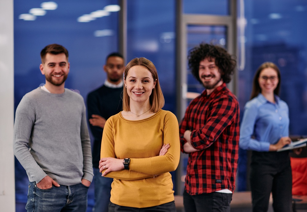 Portrait of successful creative business team looking at camera and smiling. Diverse business people standing together at startup.